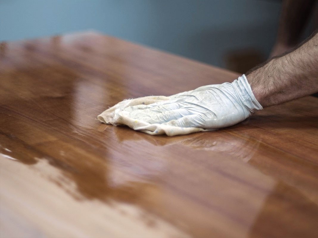 Geölte Holzoberfläche mit Ölflasche und Tuch auf Eichenholz – Anleitung zum Ölen von Holzmöbeln