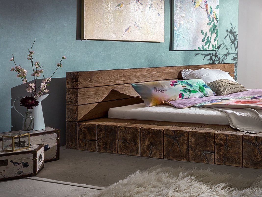 Rustikales Balkenbett aus Massivholz im Landhausstil, naturbelassene Holzmaserung, gemütliches Schlafzimmer-Ambiente