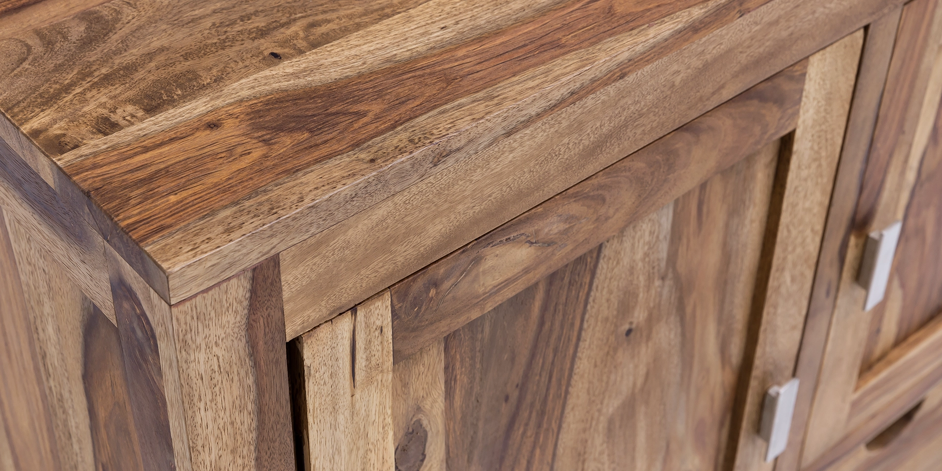 Detailaufnahme der warmen Holzmaserung und Kante des "Lagos" Massivholzprodukts, geölte Oberfläche, natürliche Farbtöne und feine Struktur