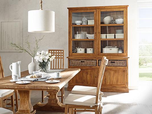 Holz-Küchenbuffet mit Glastüren und offenen Regalen, Geschirrschrank im Landhausstil, dekorativ bestücktes Geschirr und warme Küchenatmosphäre