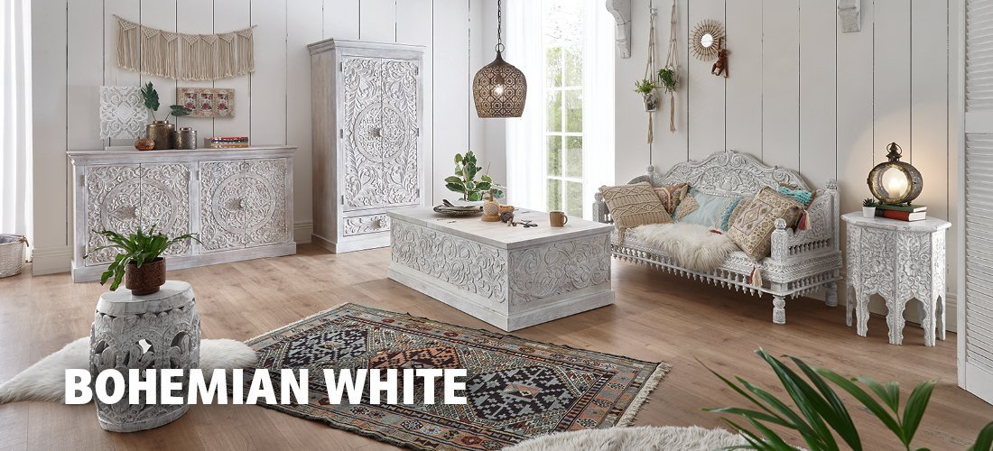 Boho-weißes Wohnzimmer mit hellem Sofa, Holz- und Rattanmöbeln, Makramee, Kissen und Zimmerpflanzen – luftiges, gemütliches Bohemian-Ambiente.