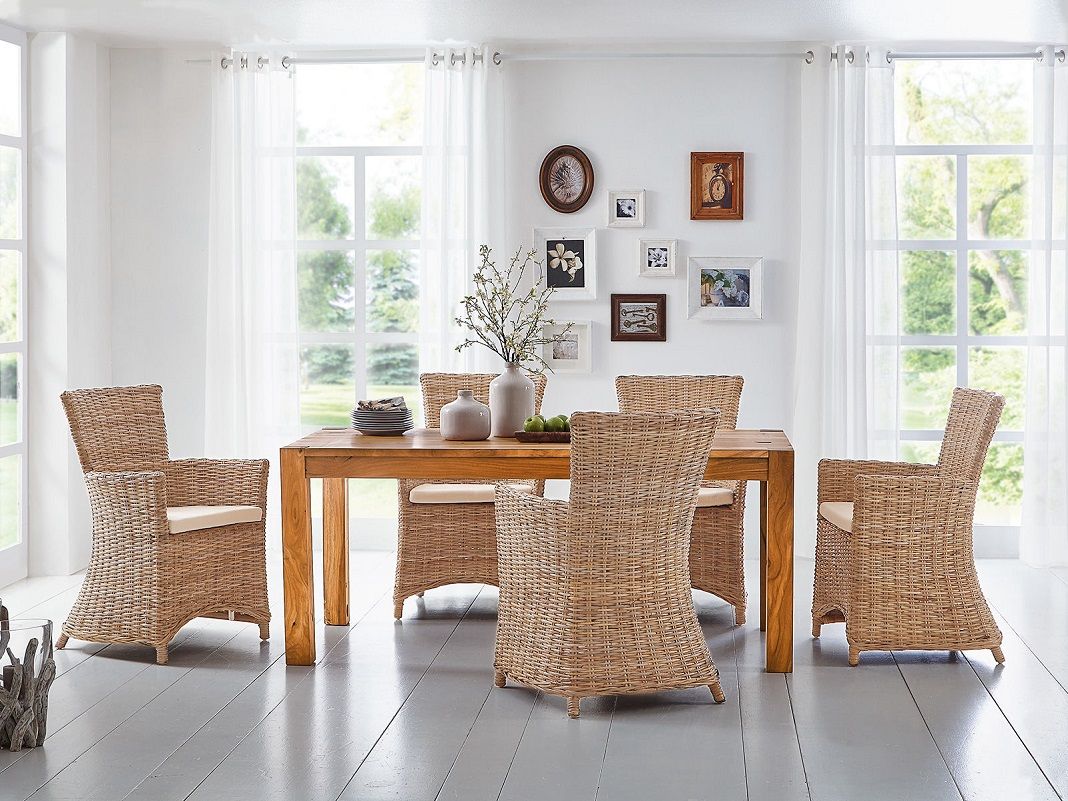 Geflechtsessel in Naturton mit Holzarmlehnen und hellem Kissen, luftiges rustikal-skandinavisches Design für Wohnraum und Terrasse