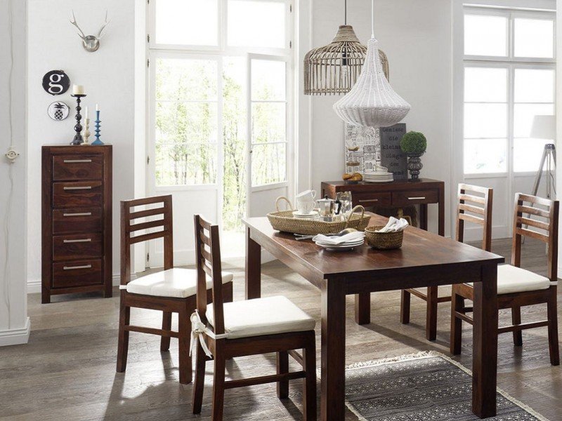 Hochkommode aus Holz im Esszimmer vor hellen Wänden, skandinavischer Stil mit Dekoration, Pflanze und minimalistischem Ambiente