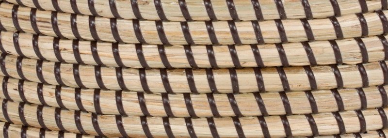 Nahaufnahme handgeflochtenes Seegrasgeflecht auf Holzrahmen, warme Naturtöne, rustikale Textur für Möbel und Sitzflächen.