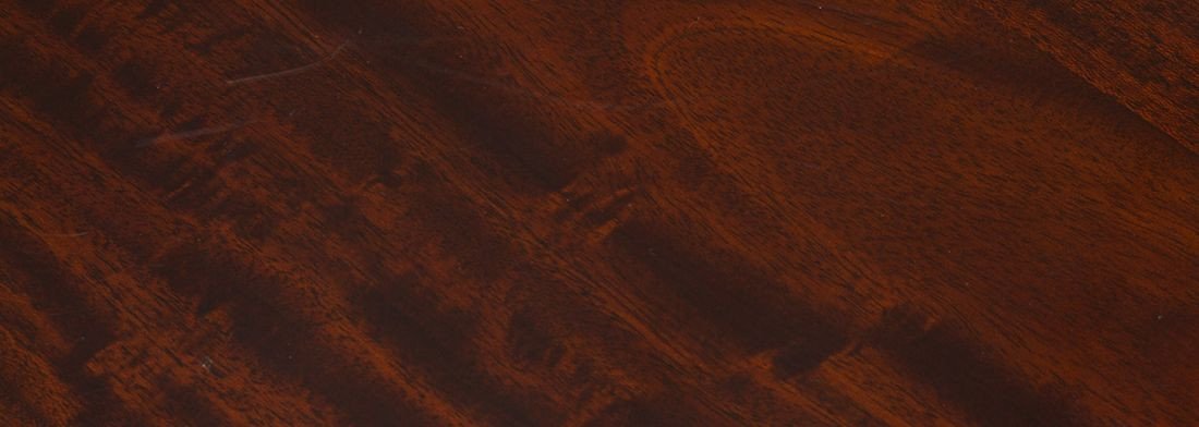 Nahaufnahme mahagonifarbenes Holzgeflecht mit feinem, regelmäßigem Flechtmuster — warme Braun- und Rottöne, Möbeloberfläche