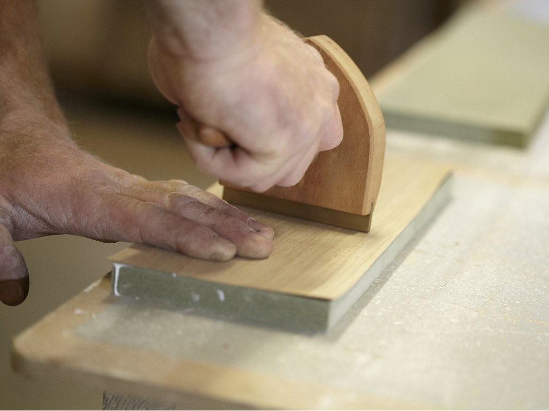 Ratgeber: Unterschied Vollholz vs. Echtholzfurnier – Holzmaserungen und Proben auf hellem Hintergrund, natürliche Holzfarben