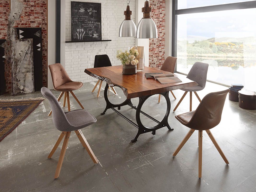 Schalenstühle im Industriestil mit dunklem Metallgestell vor warmem Holzboden – modernes, ruhiges Esszimmer-Ambiente.