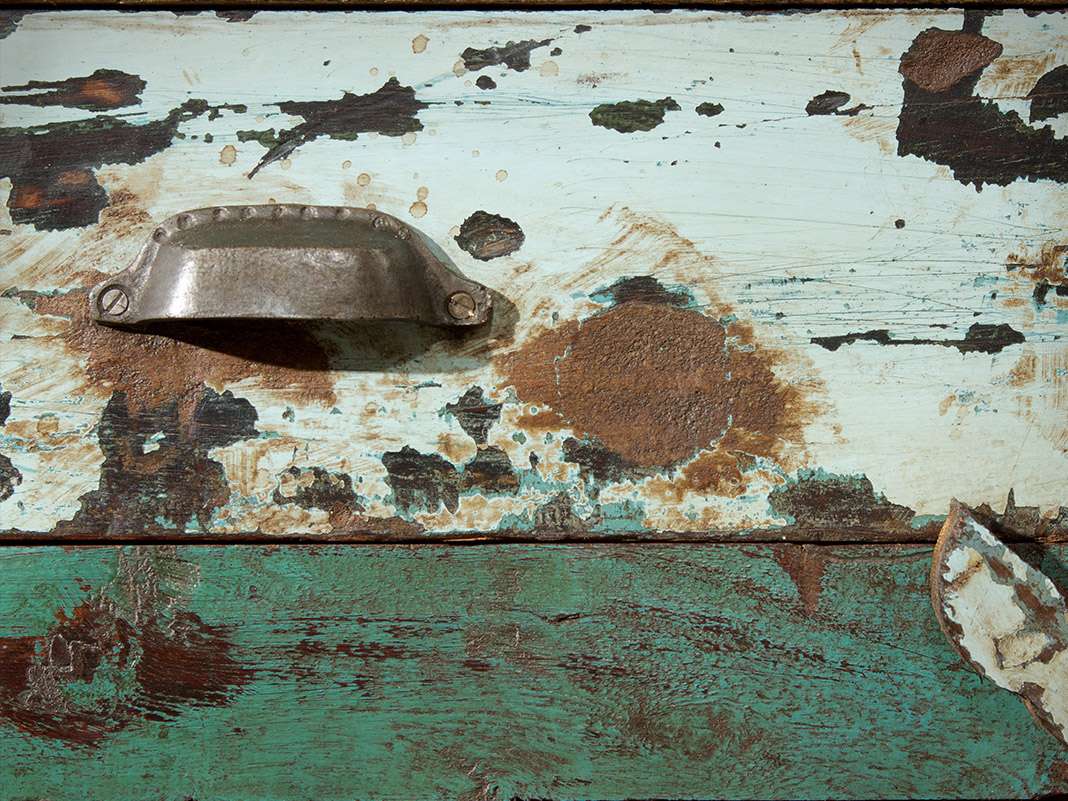 Rustikale Schubladenfronten aus Altholz mit verbliebenen Lackresten, bunte Farbspuren, shabby-chic Look für Vintage-Möbel.