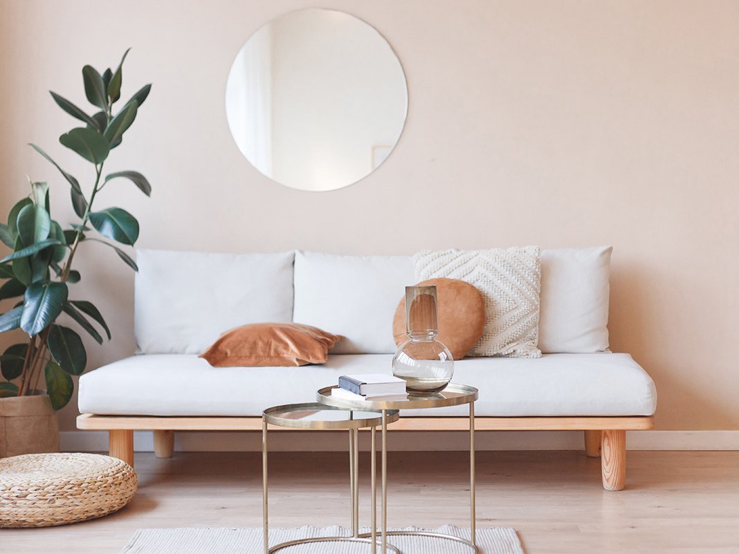 Schlafsofa als Daybed in modernem Wohnambiente mit Kissen und Decke, helles Holzfußboden, gemütlicher skandinavischer Stil